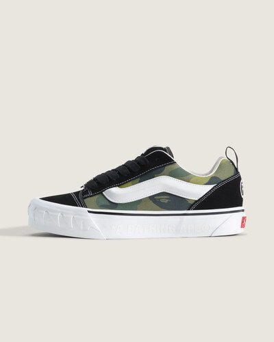<p>Inspirado no legado do streetwear, o ícone japonês BAPE traz sua estampa camuflada característica, o icônico logotipo “STA” em formato de estrela e os detalhes de dentes de tubarão para o marcante Knu Skool de proporções oversized. A silhueta inspirada nos anos 90 combina o design inconfundível da BAPE com cabedal de camurça, Sidestripe™ 3D acolchoada e sola com estampa Checkerboard.</p>