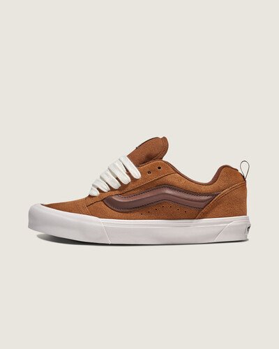 Um ícone inchado dos anos 90, reimaginado

Nascidos em 1998, os Knu Suede Skool dão um toque ousado ao icónico Old Skool da Vans. Com atacadores grandes, língua bufante e gola macia, ele deu vida às vibrações do skate dos anos 90, ao mesmo tempo que se manteve firme na construção inferior da sola waffle vulcanizada e exclusiva da Vans. Seu design exagerado na parte superior o tornou um destaque na cultura do skate. Após o seu lançamento inicial, o Knu Skool foi relançado no início dos anos 2000 e novamente em 2023, sempre combinando o seu estilo nostálgico com conforto moderno para atrair as novas gerações de entusiastas de ténis.